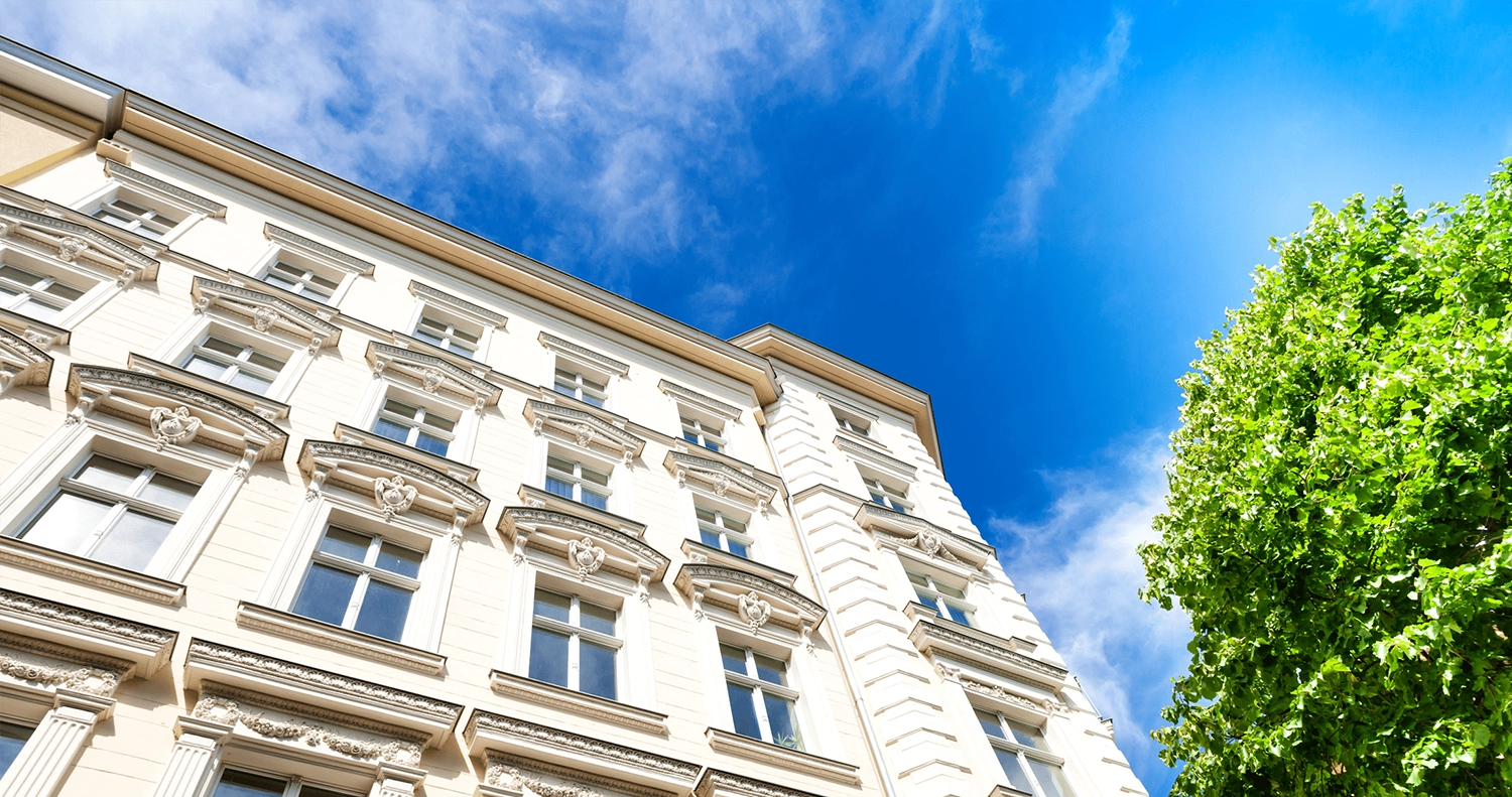 Foto von einer Hausfassade von unten fotografiert mit blauem Himmel